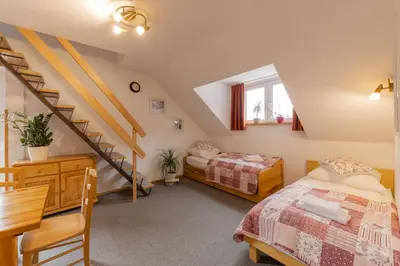 a bedroom with two beds and a staircase at Apartments Rozle in Kranjska Gora