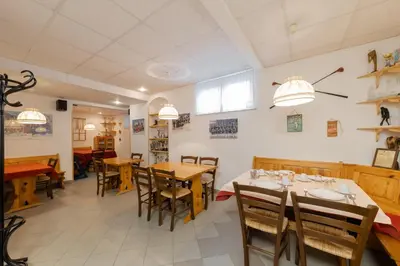 a dining room with wooden tables and chairs at Apartments Rozle in Kranjska Gora