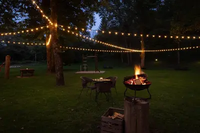a fire pit in a yard with a string of lights at Penzion Pibernik in Bled