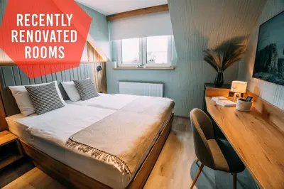 a bedroom with a bed and a sign that reads recently renovated rooms at Guest House Pohorska Kavarna in Maribor