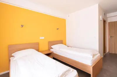 two beds in a room with yellow walls at Grajski Dvor in Radovljica