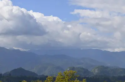 a view of a mountain range with clouds and trees at Grajski Dvor in Radovljica