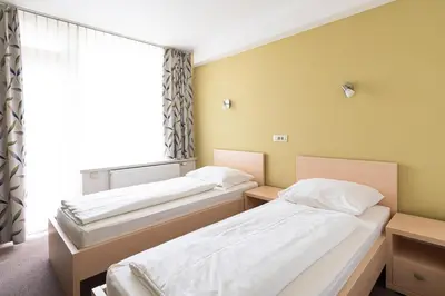 two beds in a room with a window at Grajski Dvor in Radovljica
