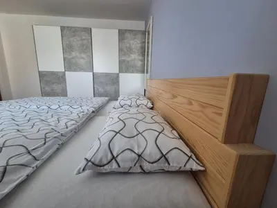 a bedroom with a bed and a wooden headboard at Apartments Silič in Bled