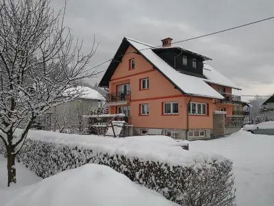 a house is covered in snow at Apartments Silič in Bled