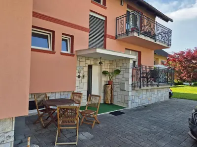 a patio with chairs and a table in front of a house at Apartments Silič in Bled