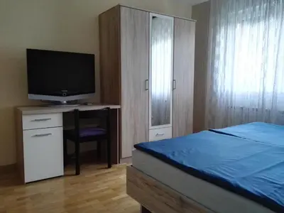 a bedroom with a bed and a desk with a television at Apartments Silič in Bled