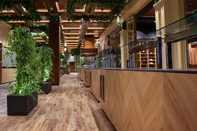 a corridor of a restaurant with potted plants at Park, Hotel & Entertainment in Nova Gorica