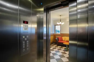 an elevator with a red couch in a waiting room at Apartments Telemark Kranjska Gora in Kranjska Gora