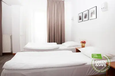 three beds in a hotel room with a green sale sign at Sabotin, Hotel & Restaurant in Nova Gorica