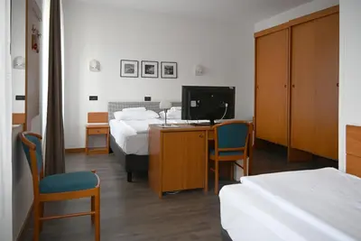 a hotel room with a bed and a desk with a television at Sabotin, Hotel & Restaurant in Nova Gorica