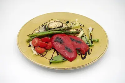 a plate of food with vegetables on a white background at Sabotin, Hotel & Restaurant in Nova Gorica