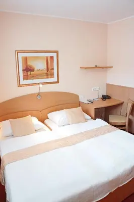 a hotel room with two beds and a desk at Guest House Pri Gondoli in Maribor
