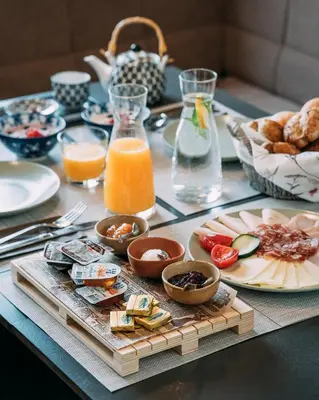 a table with breakfast foods and orange juice on it at Guest House Pri Gondoli in Maribor