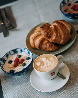 a plate with a cup of coffee and a plate of bread at Guest House Pri Gondoli in Maribor