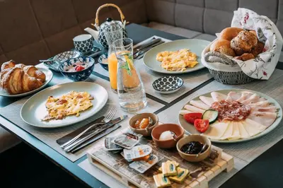 a table with plates of food on top of it at Guest House Pri Gondoli in Maribor