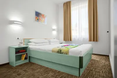 a bedroom with a bed and a window at Lipa, Hotel & Bistro in Nova Gorica