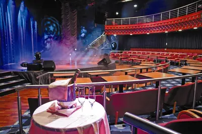 an empty theatre with a table with wine glasses on it at Korona, Resort & Entertainment in Kranjska Gora