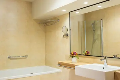 a bathroom with a sink and a tub and a mirror at Korona, Resort & Entertainment in Kranjska Gora