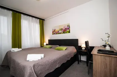 a bedroom with a bed and a desk with a computer at Hotel Faraon in Celje