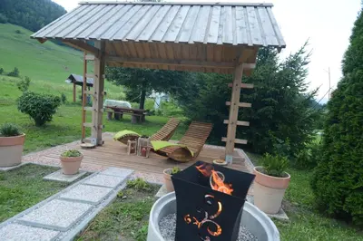 a wooden deck with a grill and a gazebo at Studio ALPIKA in Luče