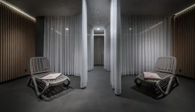 two chairs in a room with white curtains at Hotel Zdravilisce - Thermana Lasko in Laško