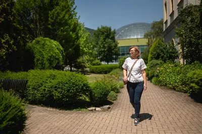 a woman walking down a brick walkway at Hotel Zdravilisce - Thermana Lasko in Laško