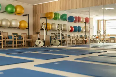 a swimming pool with blue mats in a room with chairs at Hotel Zdravilisce - Thermana Lasko in Laško
