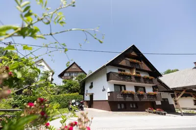 a building with flowers on the balconies of it at Apartments and rooms Pri Urhu in Bohinj