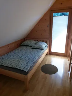 a bedroom with a bed and a large window at Brunarica in Globoko