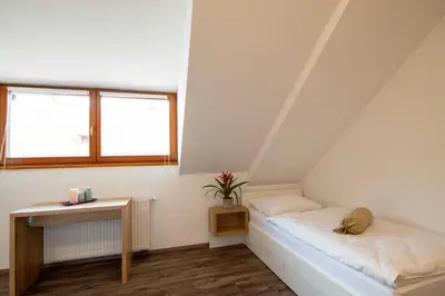 a attic room with a bed and a table at Guesthouse Stari Mayr in Kranj