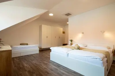 a bedroom with two beds and a white couch at Guesthouse Stari Mayr in Kranj