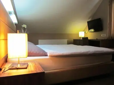 a bedroom with a bed and a lamp on a table at Hotel Opara in Trebnje