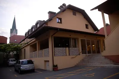 a building with a car parked in a parking lot at Hotel Opara in Trebnje