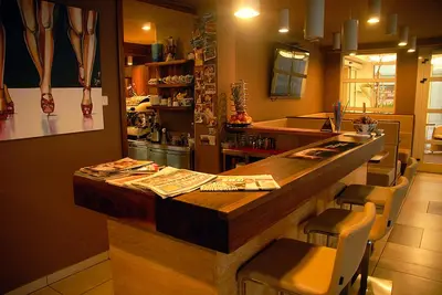 a kitchen with a counter and a bar with chairs at Hotel Opara in Trebnje