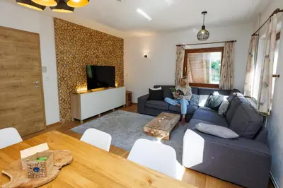a woman sitting on a couch in a living room at Chalet Ana Bohinj in Bohinj