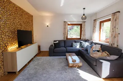a living room with a blue couch and a tv at Chalet Ana Bohinj in Bohinj