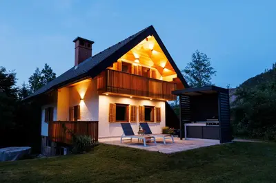 a house with two chairs sitting on a patio at Chalet Ana Bohinj in Bohinj