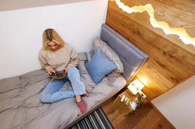 a woman sitting on a bed in a room at Chalet Ana Bohinj in Bohinj