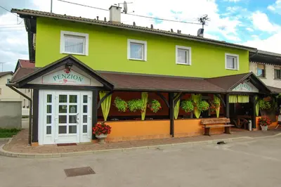 a green building with a bench in front of it at Penzion Pri Slovenc in Dol pri Ljubljani