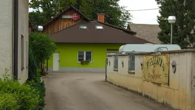 a yellow house with a black roof at Penzion Pri Slovenc in Dol pri Ljubljani
