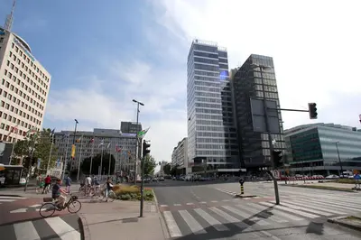 a city street with people crossing a crosswalk in a city at Skyscraper Apartment Tour As Ljubljana in Ljubljana