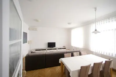 a living room with a table and a tv at Skyscraper Apartment Tour As Ljubljana in Ljubljana