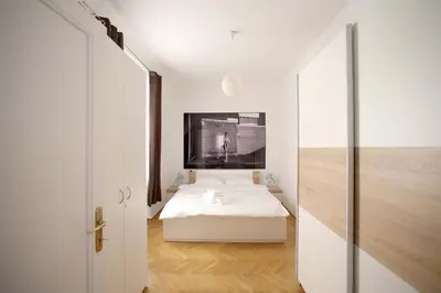 a bedroom with a white bed and a sliding door at Skyscraper Apartment Tour As Ljubljana in Ljubljana