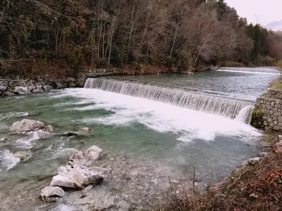 a waterfall in the middle of a river at River Cave Apartment Slovenia in Visoko