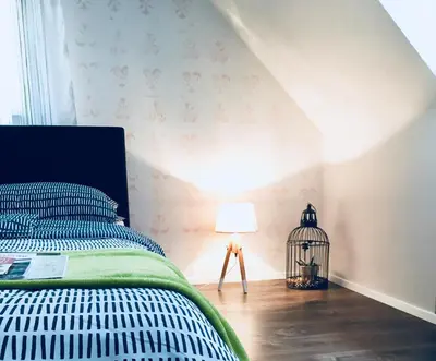 a bedroom with a bed with a lamp and a wall at Urban herbs apartment in Ljubljana