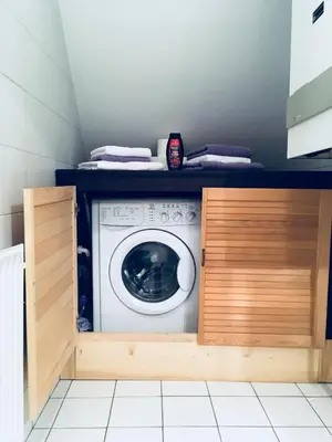 a washer and dryer in a small kitchen with a counter at Urban herbs apartment in Ljubljana