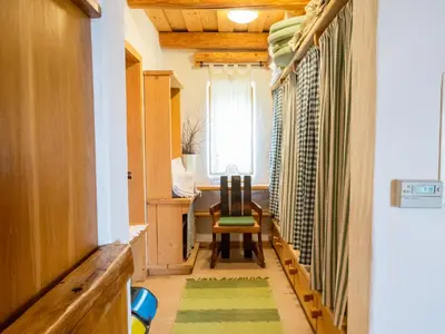 a hallway with a table and chairs and a window at Kmečka Hiška - Hiša vina Cuk in Lendava