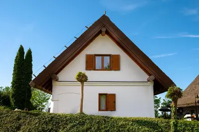 a small white house with a gambrel roof at Kmečka Hiška - Hiša vina Cuk in Lendava