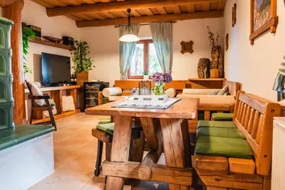 a living room with a wooden table and chairs at Kmečka Hiška - Hiša vina Cuk in Lendava